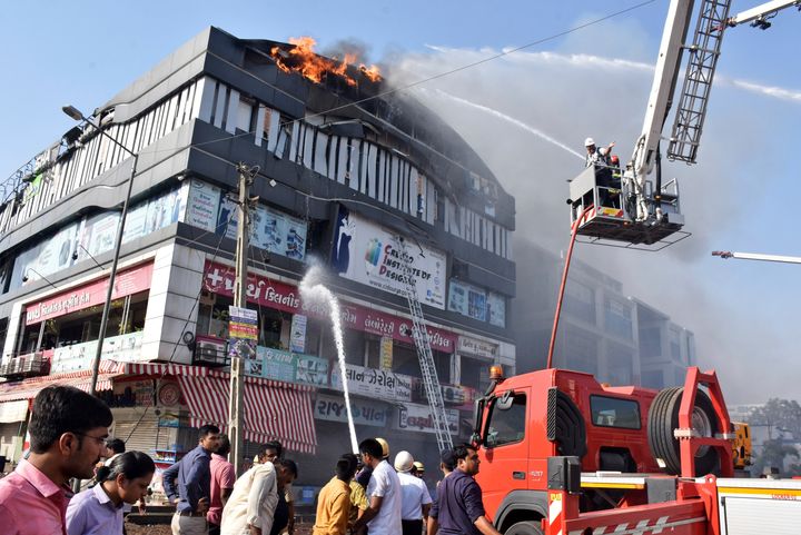 Firefighters work to douse flames on a building in Surat. 