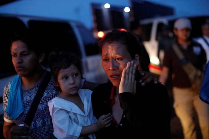 A woman, part of a convoy of Central American migrants, is escorted into a van by National Institute of Migration (INM) officers, after being detained at a checkpoint on the outskirts of Tapachula, Mexico on May 19, 2019.