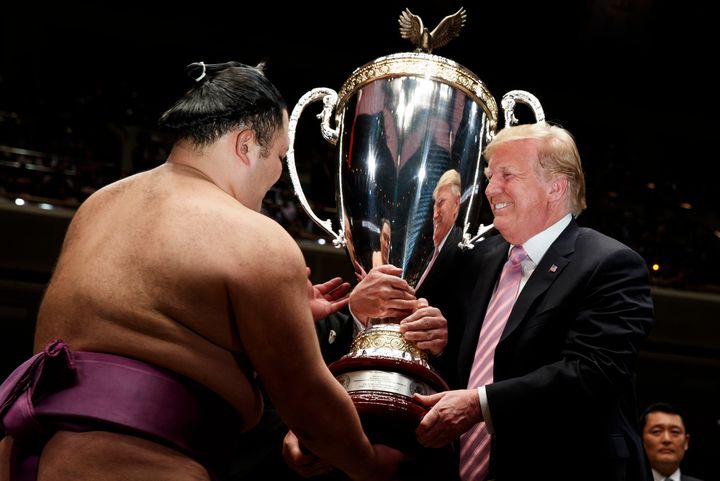 President Donald Trump presents the "President's Cup" to Tokyo Grand Sumo Tournament winner Asanoyama at Ryogoku Kokugikan Stadium on Sunday.