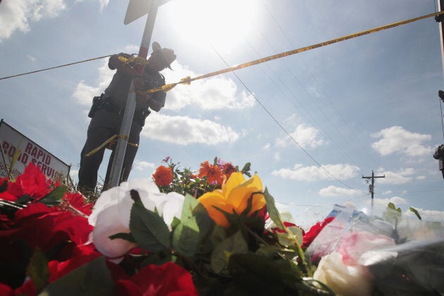 A police officer ties off crime scene tape near a small memorial close to the First Baptist Church of Sutherland Springs on Nov. 7, 2017 in Sutherland Springs, Texas.