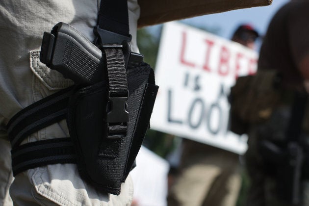 An armed gun rights activist counter-protests during a gun control rally outside the headquarters of National Rifle Association July 14, 2017 in Fairfax, Va.