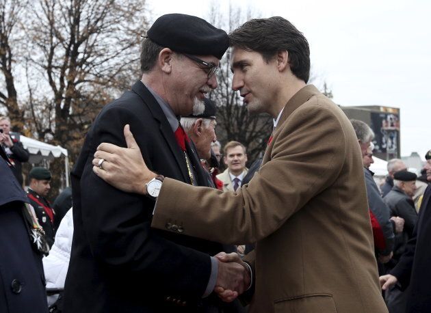 Canada's Prime Minister Justin Trudeau greets a veteran during Remembrance Day ceremonies at the National War Memorial in Ottawa on Nov. 11, 2015.