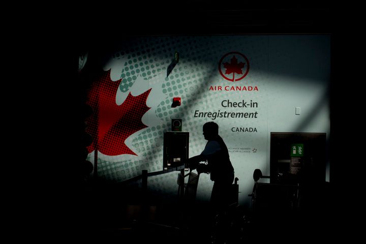 The silhouette of an Air Canada employee is seen near a check-in counter at Toronto Pearson International Airport in 2013.