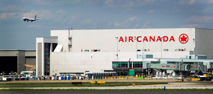 A plane passes over an Air Canada hangar at Toronto Pearson International Airport on Aug. 30, 2011.