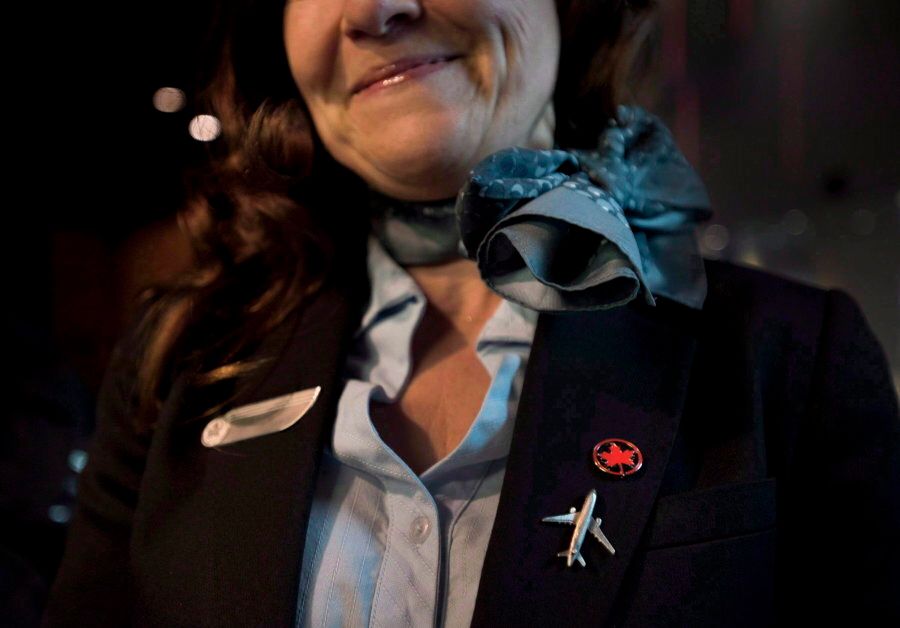 A flight attendant smiles while posing at Air Canada's annual general meeting in Toronto on May 12, 2015.