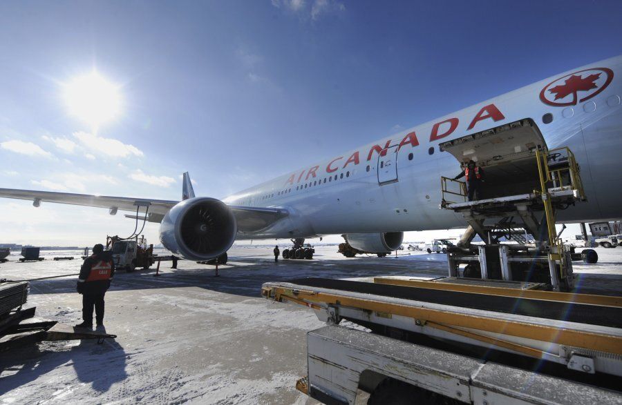 Ground crew workers load baggage into an Air Canada flight on Jan. 8, 2014 in Toronto.