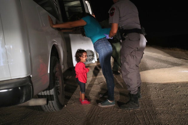 A two-year-old Honduran asylum seeker cries as her mother is searched and detained near the U.S.-Mexico border on June 12, in McAllen, Texas.