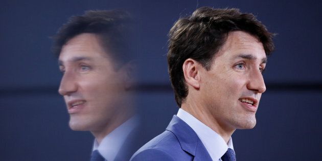 Prime Minister Justin Trudeau is reflected in a monitor while speaking during a news conference in Ottawa on June 20, 2018.