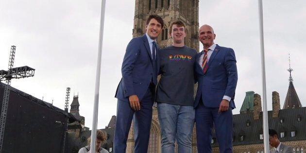 Prime Minister Justin Trudeau, Ryan Brown of Owen Sound, and MP Randy Boissonnault, right, pose for a photo at a pride flag raising ceremony on Parliament Hill in Ottawa on June 20, 2018.