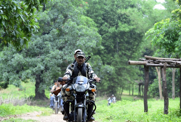 CRPF personnel drive by motorbike to conduct patrols through a village in Giridih district of