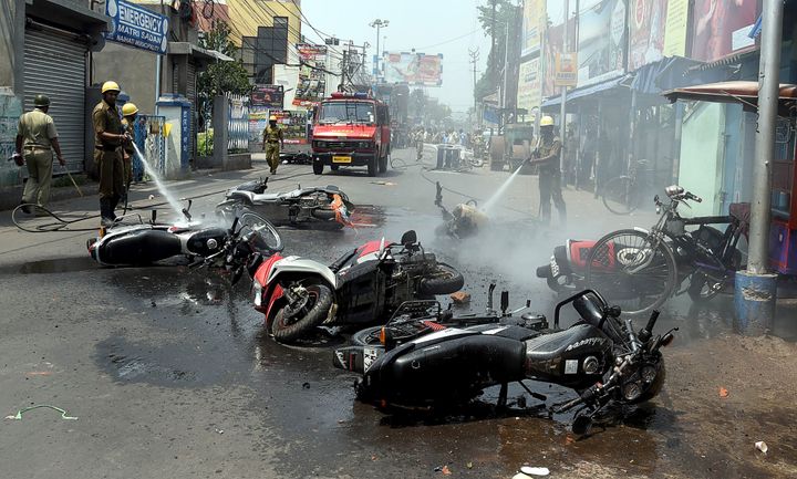 Firemen douse burned vehicles after clashes between Trinamool Congress and Bharatiya Janata Party workers in Naihati in a photo taken on 24 May. 