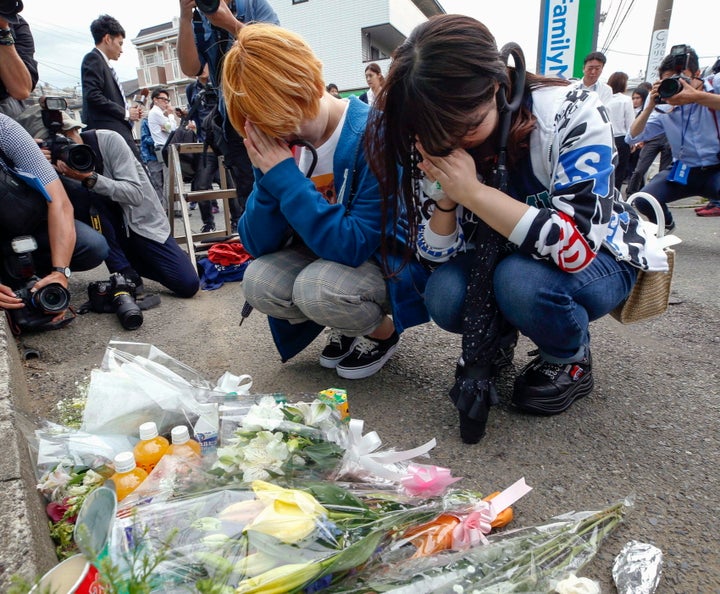 Women pray after offering flowers near the scene of a deadly knife attack in Kawasaka, Japan, which is just outside of Tokyo, on May 28, 2019.