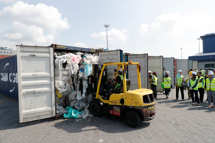 Officers from the Ministry of Environment examine a container full of non-recyclable plastic which was detained by authorities at the west port in Klang, Malaysia, on Tuesday.