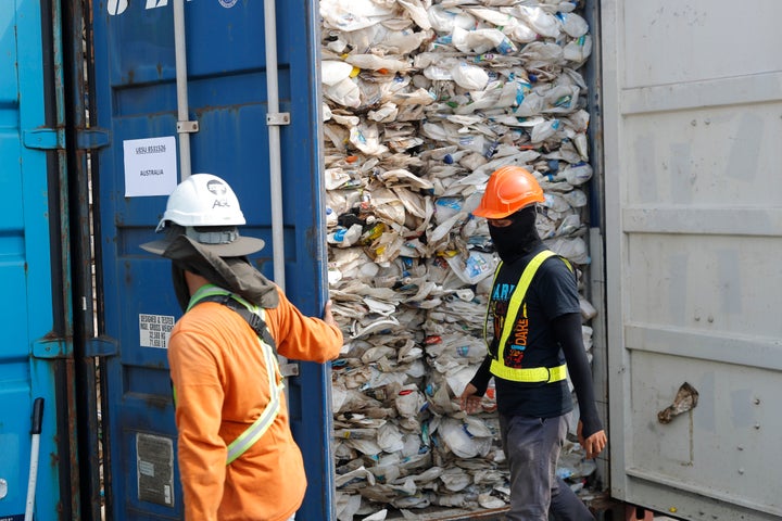 Workers open a container full of non-recyclable plastic detained by authorities at the west port in Klang, Malaysia.