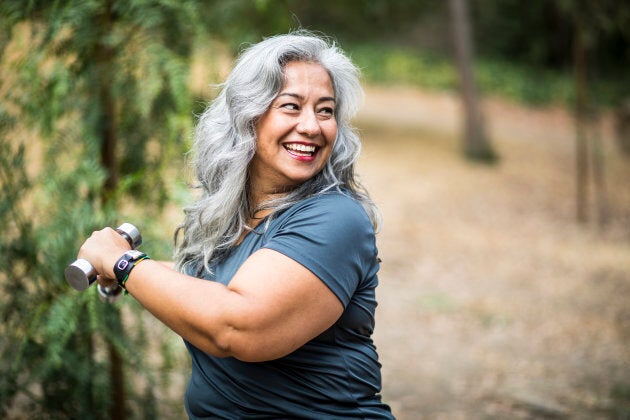 A beautiful senior Mexican Woman working out and stretching with weights