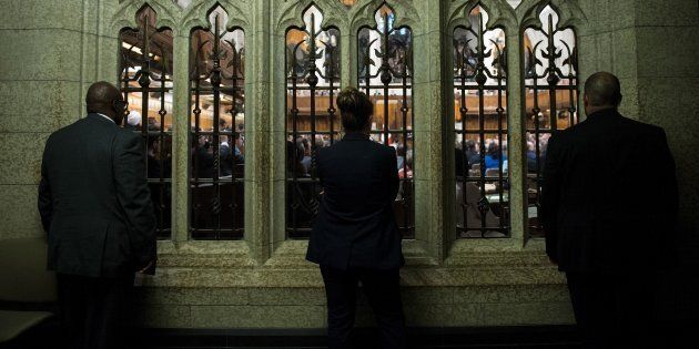 People listen from outside the chamber in the House of Commons on June 29, 2016 in Ottawa.