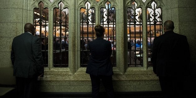 People listen from outside the chamber in the House of Commons on June 29, 2016 in Ottawa.