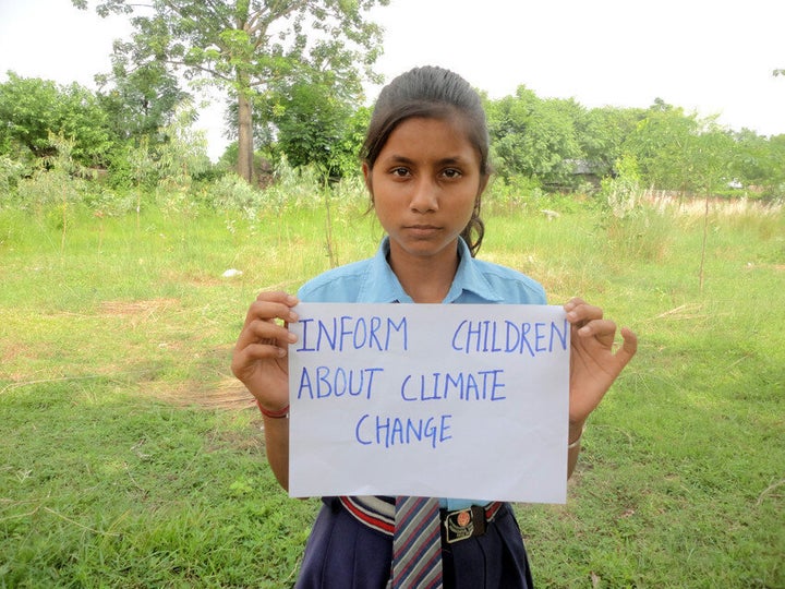 In Nepal, Sanchita, 12, holds a message reading 'Inform children about climate change.'