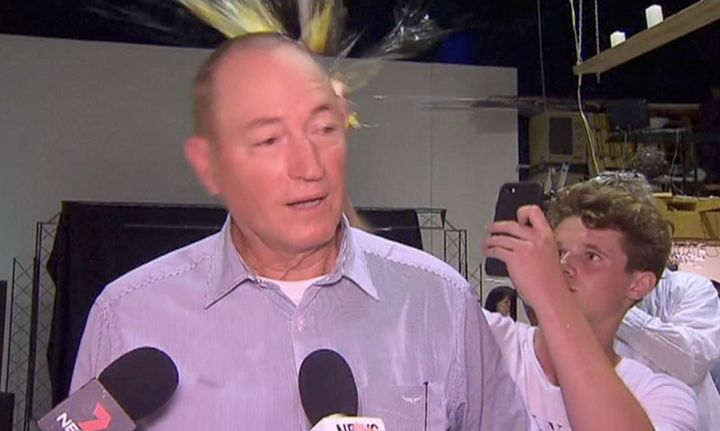 This file image made from video shows Will Connolly just as he's breaking an egg on the head of then-Sen. Fraser Anning as the anti-Muslim politician held a press conference in Melbourne, Australia.