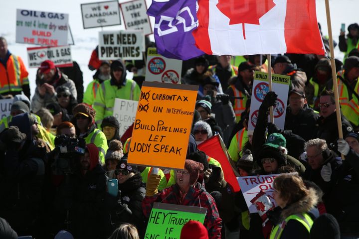 Supporters hold signs during a United We Roll Convoy in front of Parliament Hill in Ottawa on Feb. 19, 2019.