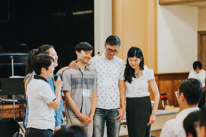 People pray for a gay engaged couple during the PAAC conference.