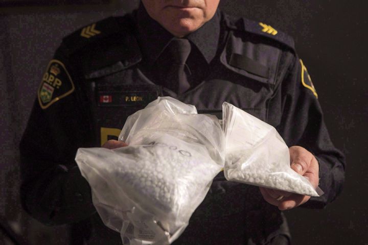 A police officer displays bags containing fentanyl as Ontario Provincial Police host a news conference in Vaughan, Ont. on Feb. 23, 2017.