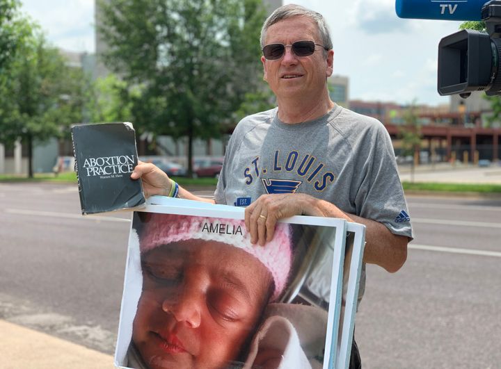 John Ryan, an anti-abortion protester, reads the "Abortion Practice" book out loud to people to dissuade them from going into the St. Louis clinic. 