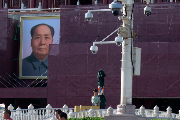 Un policier placé aux abords de la place Tiananmen et devant un portrait de Mao Zedong, en mai