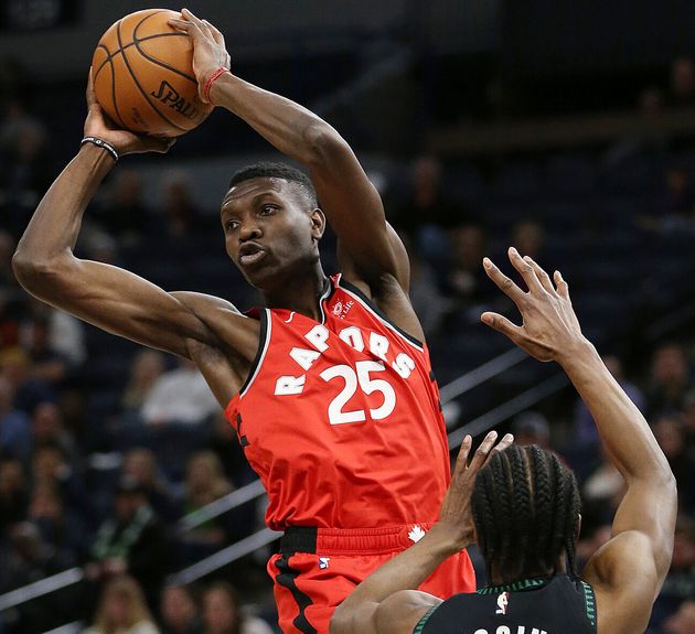 Toronto Raptors' Chris Boucher passes the ball away from Minnesota Timberwolves' Andrew Wiggins during the second half of an NBA basketball game on April 9, 2019.