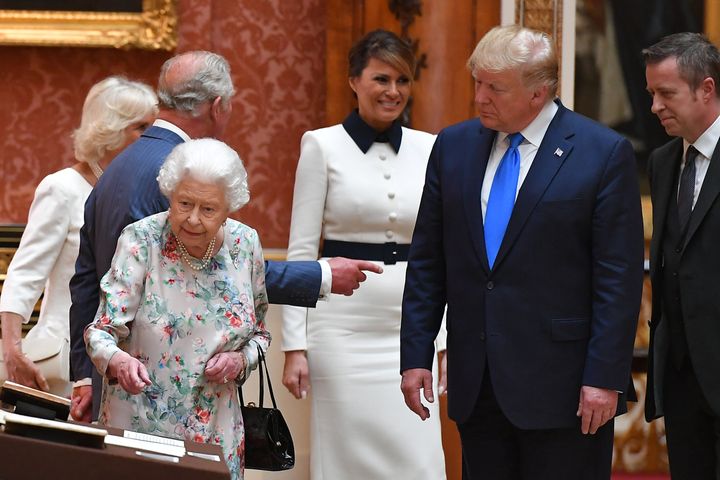 The Queen shows President Trump an exhibit during a tour of the Royal Collection at Buckingham Palace.