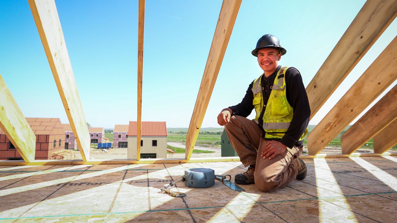 Alan Jealous, co-owner of Thikaga Construction, kneels on a house his company is building for the Thunder Valley Community Development Corporation on the Pine Ridge Reservation.