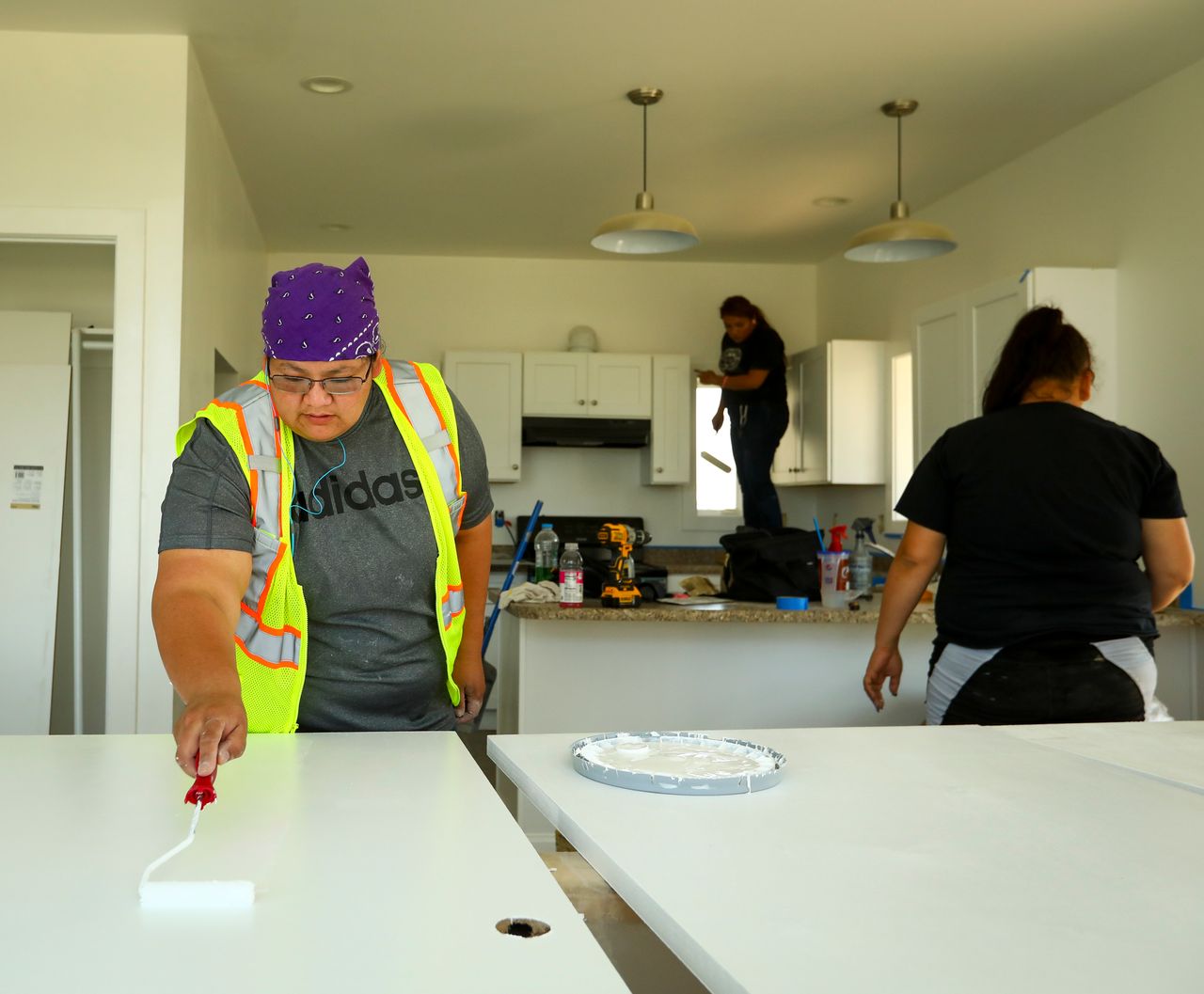 Marie Kills Warrior, 26, applies a second coat of paint to doors in a Thunder Valley CDC affordable housing unit on the Pine Ridge Reservation on May 31, 2019.