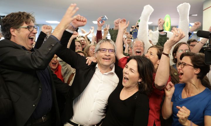 German Greens party top candidate Sven Giegold (L) and co-leader of the Green party Annalena Baerbock (C) celebrate as exit poll are announced on public broadcast TV stations during the election evening on May 26, 2019 in Berlin following the European parliament election.