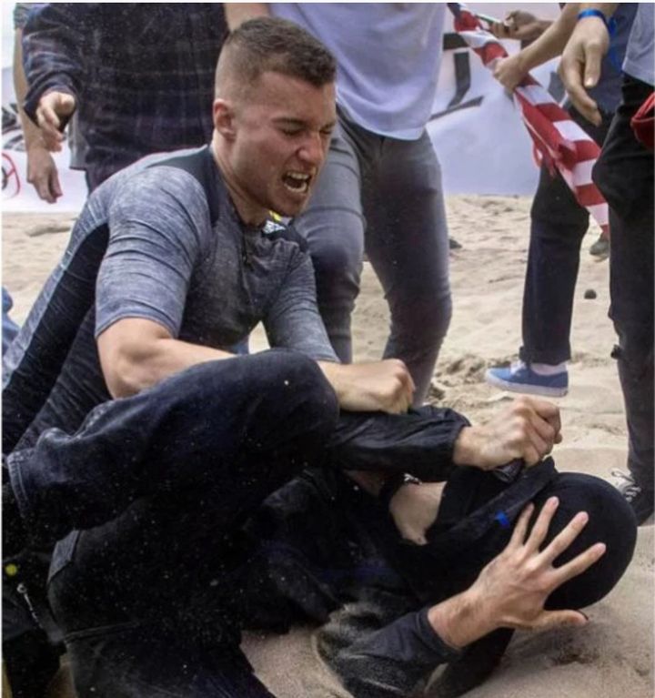 Robert Rundo, a founder of the neo-Nazi Rise Above Movement, punches a counter-protester during a political rally at Bolsa Chica State Beach, California, on March 25, 2017.