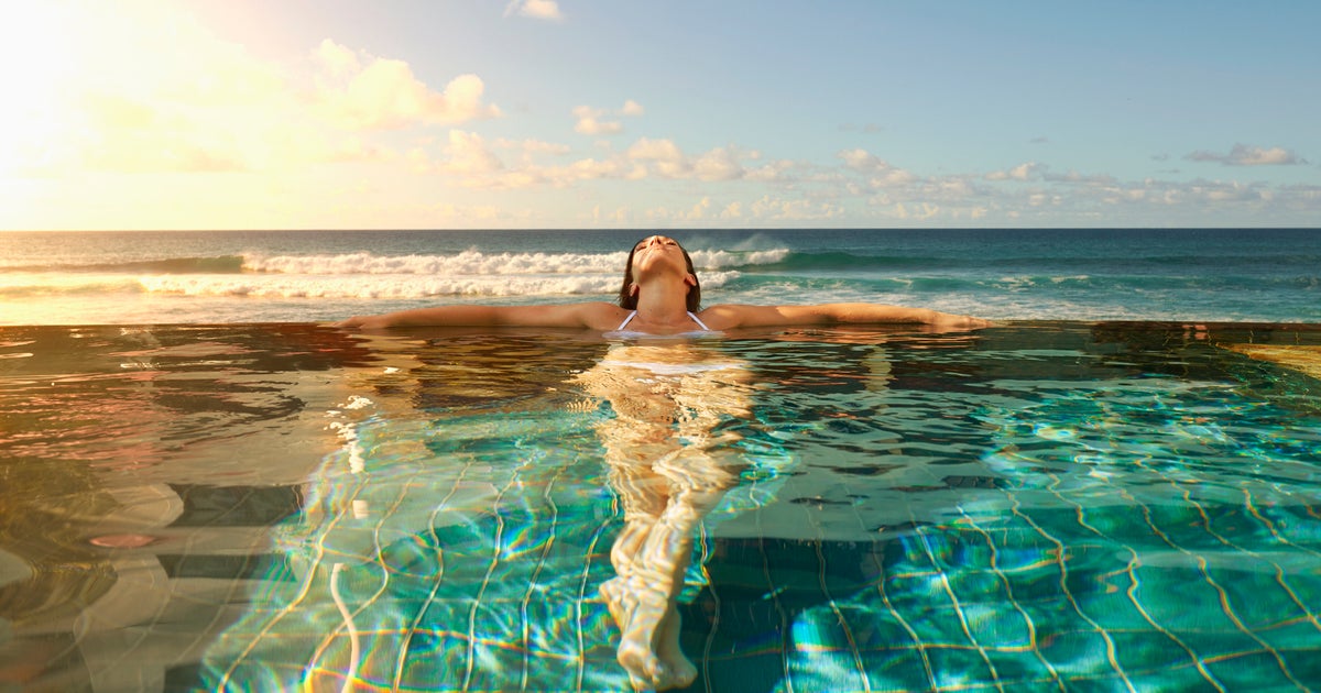 Девушка в бассейне. Swimming is more relaxing most relaxing. Back view of going to the swimming pool. Море релакс. Устал плыть.