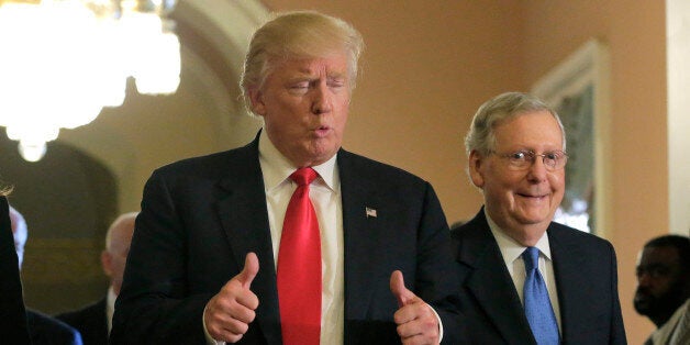 U.S. President-elect Donald Trump (L) gives a thumbs up sign as he walks with Senate Majority Leader Mitch McConnell (R-KY) o