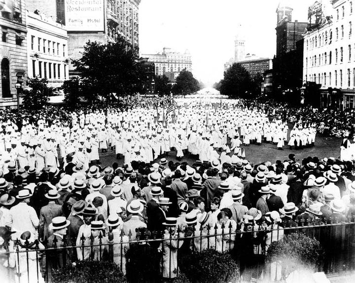 Members of the Ku Klux Klan, wearing traditional white robes, parade down Pennsylvania Avenue past the Treasury Building in Washington, D.C., in 1925.