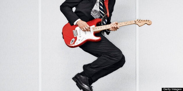 Man jumps off desk while playing guitar