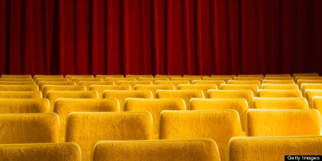 Empty seats in theater or auditorium with red velvet drapery wall