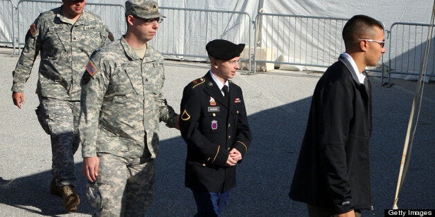 FORT MEADE, MD - JUNE 06: U.S. Army Private Bradley Manning (2nd R) is escorted during his arrival to military court on the first day of a three-day motion hearing June 6, 2012 in Fort Meade, Maryland. Manning, an Army intelligence analyst, has been accused of passing thousands of diplomatic cables and intelligence reports to the whistleblowing website WikiLeaks and faces 22 charges, including aiding the enemy. Manning returned to court to ask for a dismissal of 10 of the charges. (Photo by Alex Wong/Getty Images)