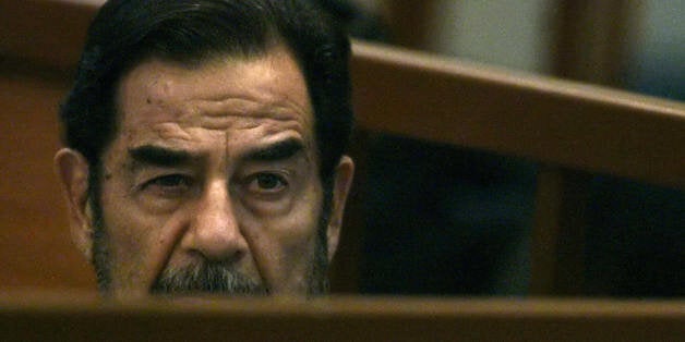 Baghdad, IRAQ: Former Iraqi leader Saddam Hussein listens to prosecutors during his trial held in Baghdad's heavily-fortified Green Zone, 30 October 2006. Iraq's ousted leader heard his genocide accusers today describe how 'Doomsday' came to their bombed villages and the smell of poisonous chemicals enveloped the scorched bodies of children clutching Eid lollipops. Hussein and 6 other co-defendants are facing charges of crimes against humanity for their roles in the Anfal military operation from 1987-88 that prosecutors say killed thousands of Iraqis. AFP PHOTO/POOL/SCOTT NELSON (Photo credit should read SCOTT NELSON/AFP/Getty Images)