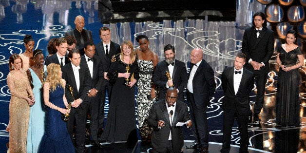 HOLLYWOOD, CA - MARCH 02: Director Steve McQueen (C) accepts the Best Picture award for '12 Years a Slave' with (back row) actors Sarah Paulson, Benedict Cumberbatch, Lupita Nyong'o, screenwriter John Ridley, actor Chiwetel Ejiofor, producers Arnon Milchan, Dede Gardner, Jeremy Kleiner and Anthony Katagas, actress Adepero Oduye and producer Brad Pitt onstage during the Oscars at the Dolby Theatre on March 2, 2014 in Hollywood, California. (Photo by Kevin Winter/Getty Images)