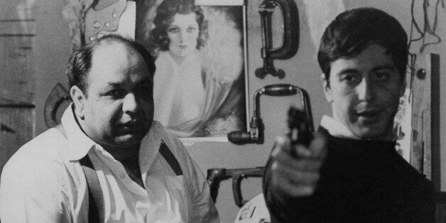 Richard S Castellano watching Al Pacino aim gun in a scene from the film 'The Godfather', 1972. (Photo by Paramount/Getty Images)