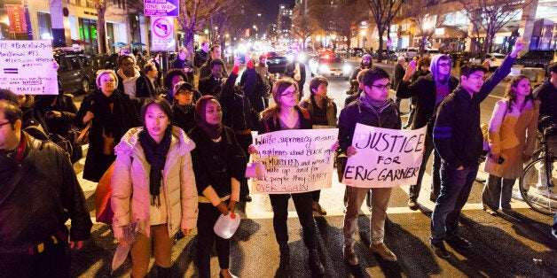 WASHINGTON, DC - DECEMBER 03 : Protestors block the road during a protest after two grand juries decided not to indict the police officers involved in the deaths of Michael Brown in Ferguson, Mo. and Eric Garner in New York, N.Y. in Washington, D.C. on December 3, 2014. (Photo by Samuel Corum/Anadolu Agency/Getty Images)