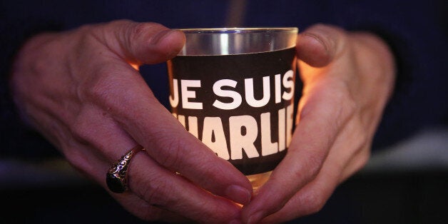 BERLIN, GERMANY - JANUARY 13: People hold candles with 'Je suis Charlie' written on them as they attend a vigil organized by Muslim groups at the Brandenburg Gate to commemorate the victims of the recent terror attacks in Paris on January 13, 2015 in Berlin, Germany. Germany is home to four million Muslims and many mosques and Muslim associations have been outspoken in condemning the recent terror sprees in Paris by Islamic extremists that left 17 people dead, including 10 employees at the satirical Charlie Hebdo magazine. (Photo by Sean Gallup/Getty Images)