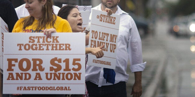 Yaneth Lonbana yells at passing cars, while marching in support of fast food workers, Thursday, May 15, 2014 in Miami. Calling for higher pay and the right to form a union without retaliation, fast-food chain workers protested Thursday as part of a wave of strikes and protests in 150 cities across the U.S. and 33 additional countries on six continents. (AP Photo/J Pat Carter)