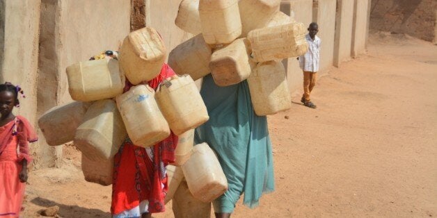 DARFUR, SUDAN - SEPTEMBER 26: Refugee woman carries plastic bottles to get water from a water-well as they try to live under hard conditions at UNICEF supported refugee camps in Darfur, Sudan on September 26, 2015. (Photo by Zekeriya Gunes/Anadolu Agency/Getty Images)