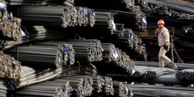 A labourer walks on the steel bars at a steel and iron factory in Changzhi, Shanxi province January 11, 2010. China's imports