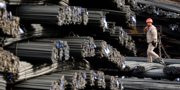 A labourer walks on the steel bars at a steel and iron factory in Changzhi, Shanxi province January 11, 2010. China's imports of iron ore hit 62.16 million tonnes in December, the second highest monthly volume ever, as a revival of steel prices helped the trade rebound for a second month, Customs data showed on Sunday. REUTERS/Stringer (CHINA - Tags: BUSINESS SOCIETY EMPLOYMENT) CHINA OUT. NO COMMERCIAL OR EDITORIAL SALES IN CHINA