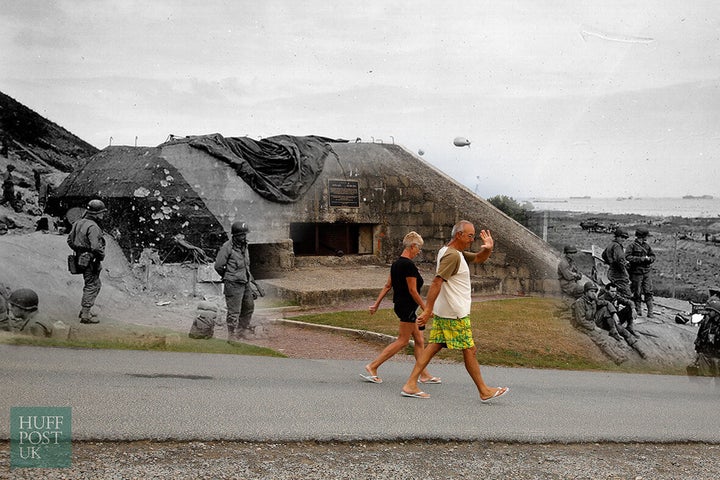 <strong>Beach goers walk past a captured German bunker overlooking Omaha Beach near Saint Laurent sur Mer.</strong>
